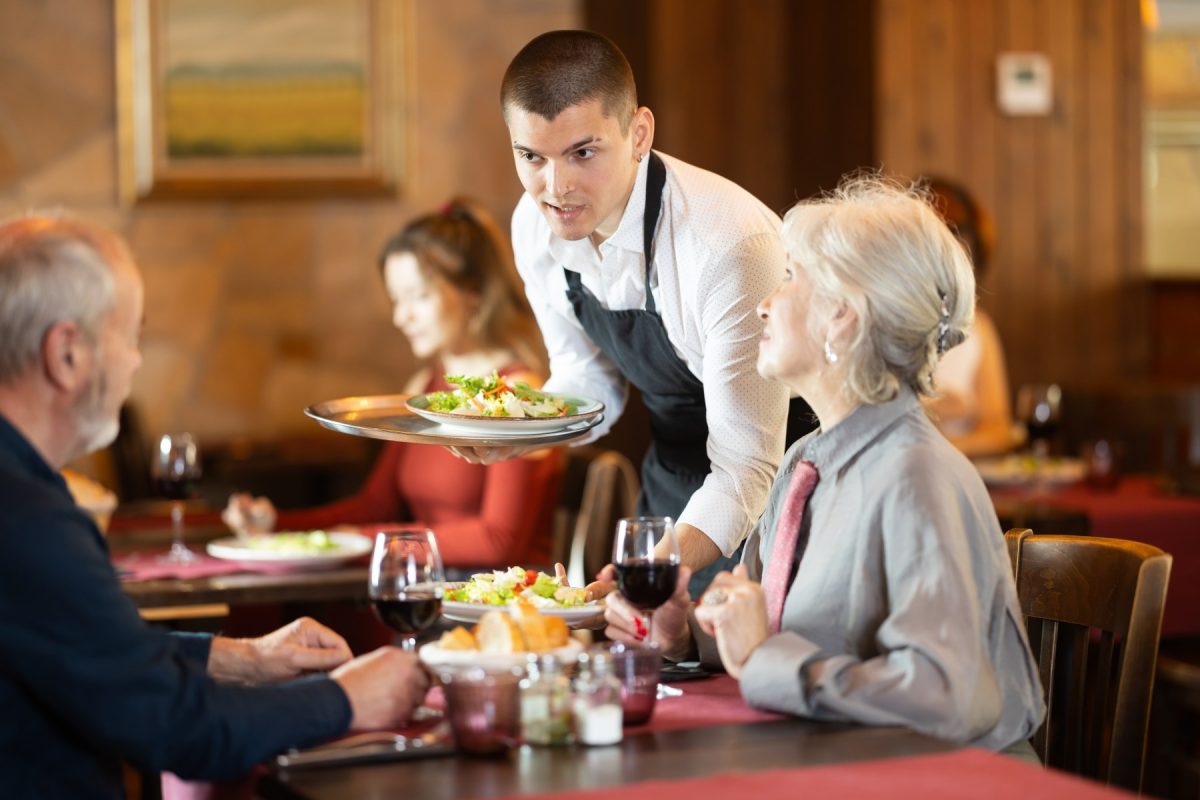 waiter bringing couple their food at a nice restaurant 